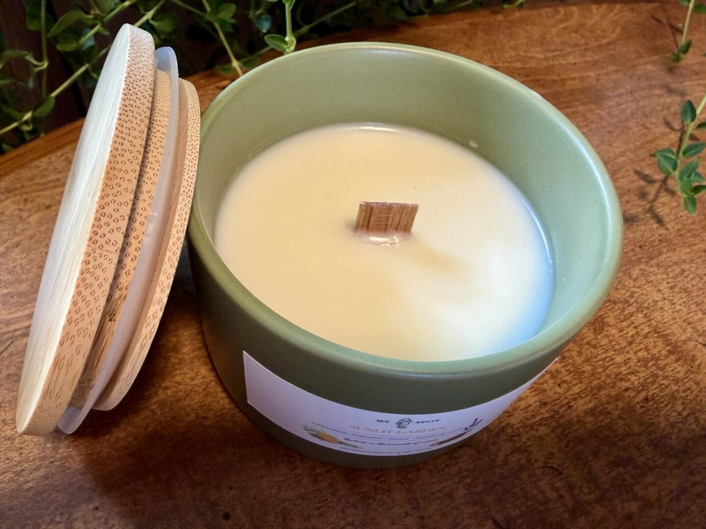 Top view of Sunlit Garden candle with wood wick in olive green ceramic vessel